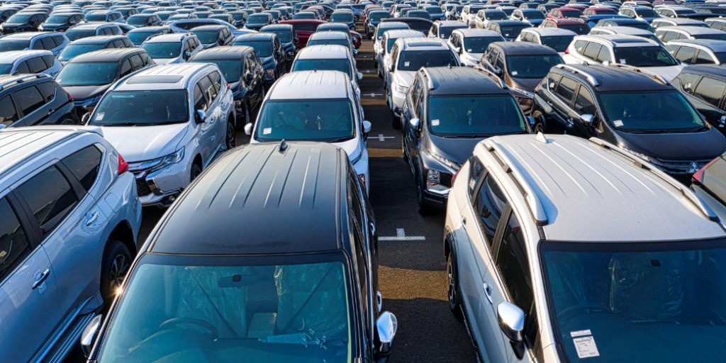 Modern shiny cars near factory in daytime
